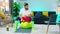 A handsome man wearing knee high green neon socks is sitting on a yellow workout ball and using yellow dung bells to