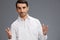 handsome man white shirt posing hand gesture emotions Gray background