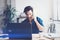 Handsome man working contemporary notebook while sitting at the wooden table at sunny office.Man talking on his mobile