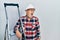 Handsome mature handyman close to construction stairs wearing hardhat angry and mad screaming frustrated and furious, shouting