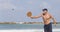 A handsome mature man hits a ball while playing matkot on the beach