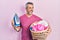 Handsome middle age man with grey hair holding electric steam iron holding laundry basket angry and mad screaming frustrated and