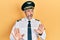 Handsome middle age man with grey hair wearing airplane pilot uniform moving away hands palms showing refusal and denial with