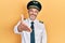 Handsome middle age man with grey hair wearing airplane pilot uniform smiling friendly offering handshake as greeting and