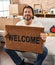 Handsome middle age man holding welcome doormat at new home smiling with a happy and cool smile on face