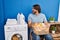 Handsome middle age man waiting for laundry looking to side, relax profile pose with natural face with confident smile