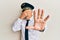 Handsome middle age mature man wearing airplane pilot uniform covering eyes with hands and doing stop gesture with sad and fear