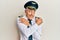 Handsome middle age mature man wearing airplane pilot uniform hugging oneself happy and positive, smiling confident