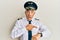 Handsome middle age mature man wearing airplane pilot uniform in hurry pointing to watch time, impatience, upset and angry for