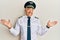 Handsome middle age mature man wearing airplane pilot uniform smiling showing both hands open palms, presenting and advertising