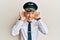 Handsome middle age mature man wearing airplane pilot uniform trying to hear both hands on ear gesture, curious for gossip