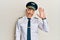 Handsome middle age mature man wearing airplane pilot uniform waiving saying hello happy and smiling, friendly welcome gesture