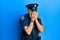 Handsome middle age mature man wearing police uniform with sad expression covering face with hands while crying