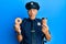 Handsome middle age mature police man eating donut and drinking coffee making fish face with mouth and squinting eyes, crazy and