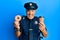 Handsome middle age mature police man eating donut and drinking coffee smiling and laughing hard out loud because funny crazy joke