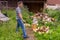 Handsome middle-aged man chopping wood with axe at backyard of country house. Man with chopper standing near woodpile