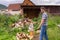 Handsome middle-aged man chopping wood with axe at backyard of country house. Man with chopper standing near woodpile