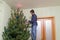 Handsome middle-aged man decorates a Christmas tree with new yea