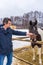 Handsome middle-aged man patting horse at ranch in snowy day. Winter weekend at farm, trip to countryside. Healthy lifestyle,