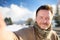 Handsome milddle age man making a self portrait selfie with snowy Bavarian Alps on background