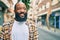 Handsome modern african american man with beard smiling positive standing at the street