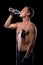 Handsome muscular athlete drinks water from a bottle