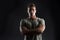 Handsome muscular fit young man on dark background with stern expression