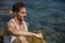 Handsome muscular man on the beach sitting on rocks