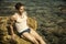 Handsome muscular man on the beach sitting on rocks