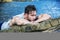 Handsome muscular man on the beach sitting on rocks