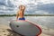 Handsome muscular man holding surfboard.