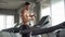 Handsome muscular man running on treadmill finished exercise drinking water and wiping sweat with towel in fitness gym . Shirtless