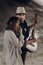 Handsome musician man with guitar and cowboy hat hug with sensual brunette hipster woman