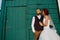 Handsome newly wed man and wife standind in front of painted wall with a door