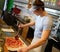 Handsome pizzaiolo making pizza at kitchen in pizzeria.