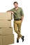 Handsome postman standing by cardboard boxes