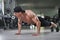 Handsome powerful athletic man performing push ups at the gym.