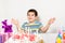 A handsome preschool boy with a cake on his birthday claps his hands on a white background.