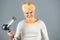 Handsome redhead man with long hair dries his hair with a hairdryer. Blonde bearded man with hair dryer.