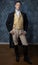 A handsome Regency gentleman wearing a gold waistcoat, breeches, and a black coat