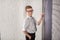 Handsome school boy in googles white shirt tie standing close to school desk with numbers above around the head.