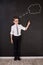 Handsome school boy in googles white shirt tie standing close to school desk with numbers above around the head.