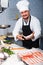 Handsome seller shows hands fish on counter