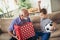 Handsome senior grandfather presenting gift to happy grandson