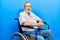 Handsome senior man with beard sitting on wheelchair with a happy and cool smile on face