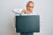 Handsome senior man holding briefcase full of dollars skeptic and nervous, frowning upset because of problem