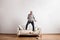 Handsome senior man standing on couch, dancing. Studio shot.