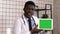Handsome serious African doctor presenting product on tablet screen. White Display.