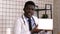 Handsome serious African doctor presenting product on tablet screen. White Display.