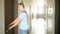 Handsome serious man in grey t-shirt opening the door with keys and entering his apartment